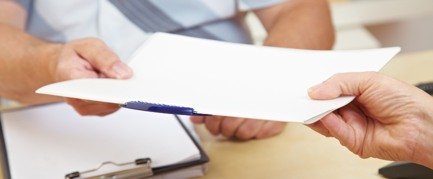 hands exchanging paper documents