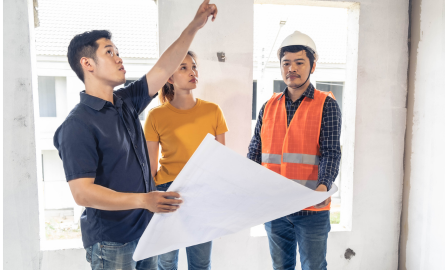 Two men and a woman reviewing building plans