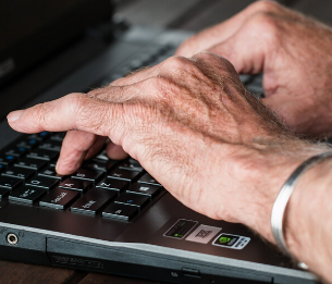 Hands typing on a computer