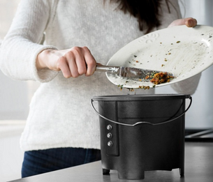 Woman scraping food scraps into FoodCycler machine