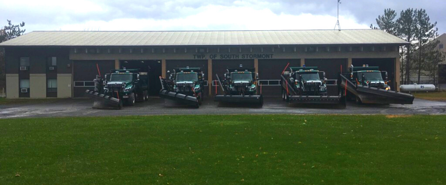 5 Snow plows parked outside garage