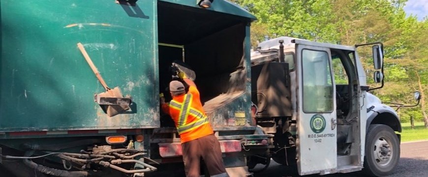Garbage collector putting garbage in truck