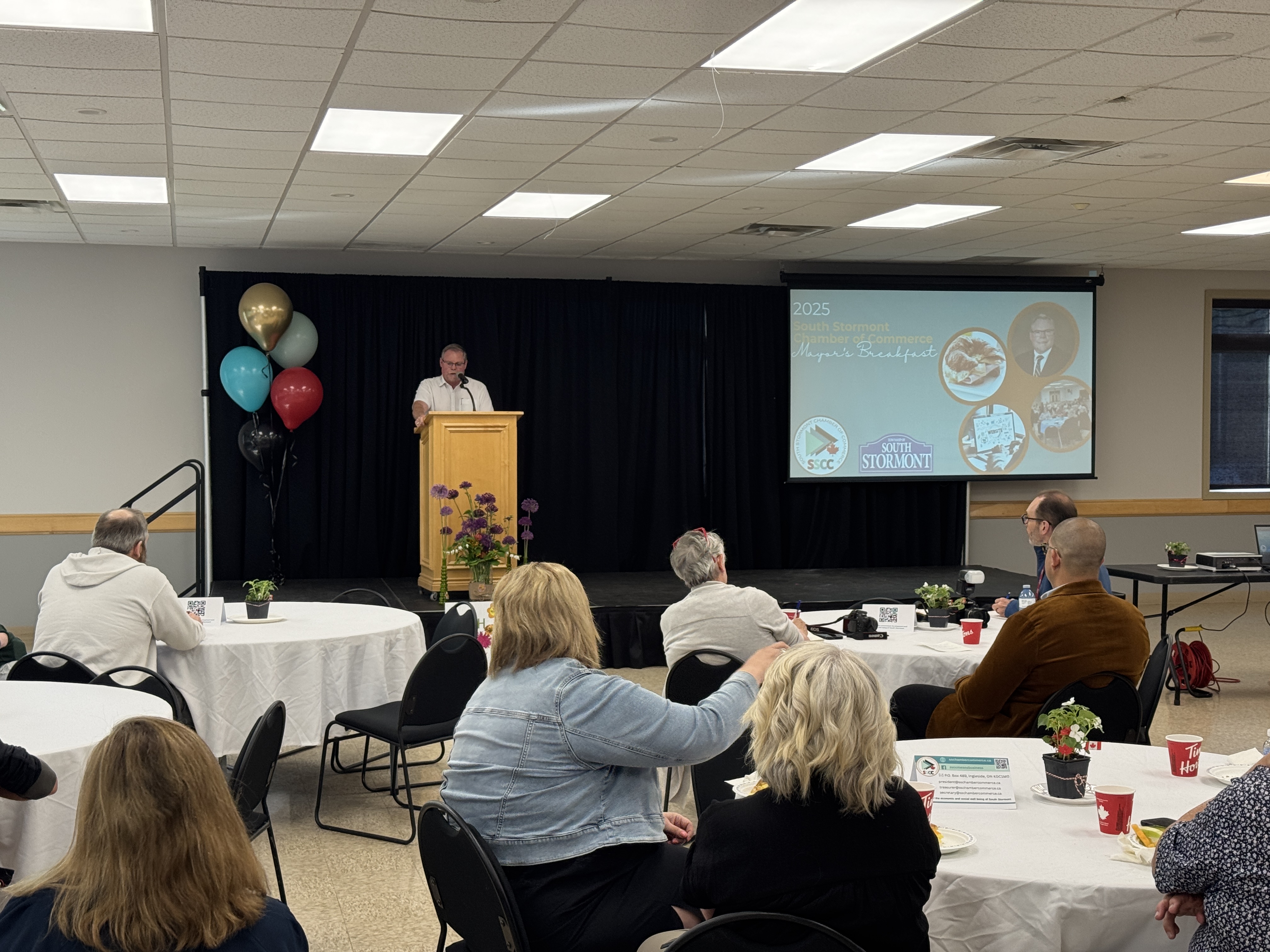 Mayor McGillis at podium speaking to crowd at breakfast event