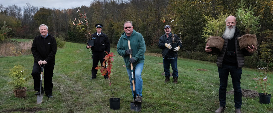 5 men posing with trees and shovels