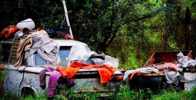 Rusted car and junk in a yard