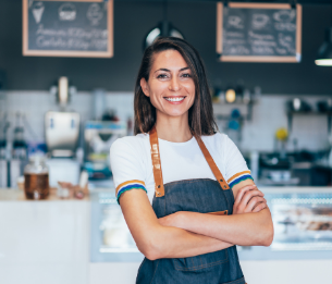 Woman in apron standing in front of cafe