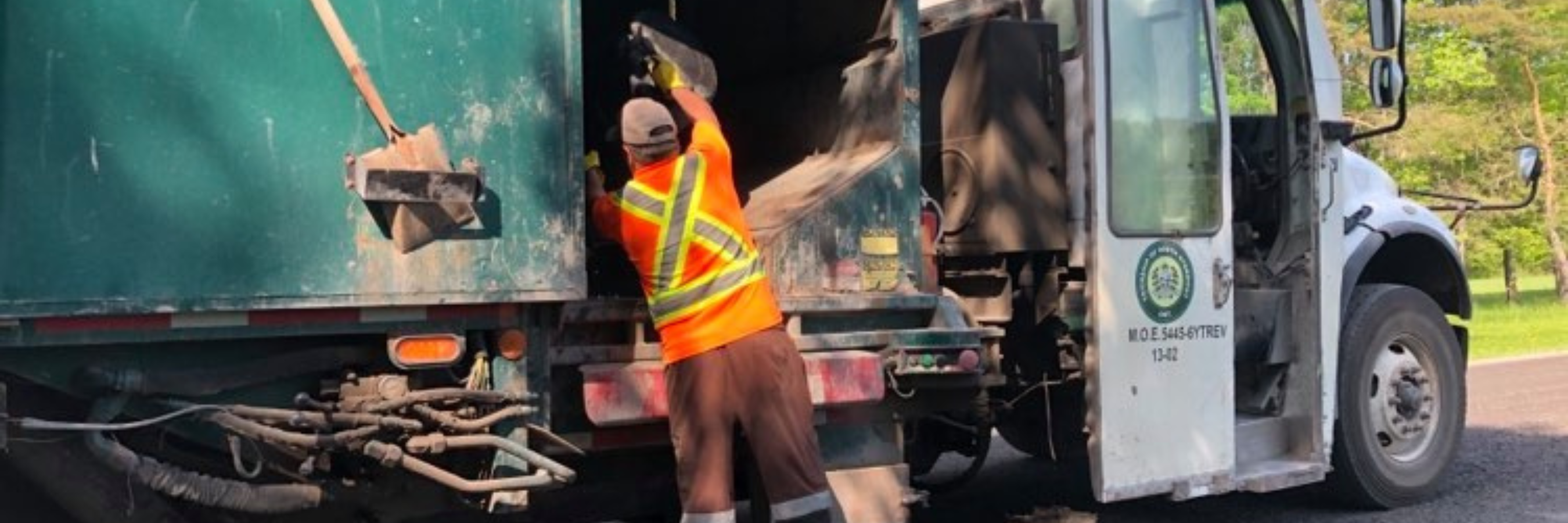 Garbage man throwing garbage into garbage truck